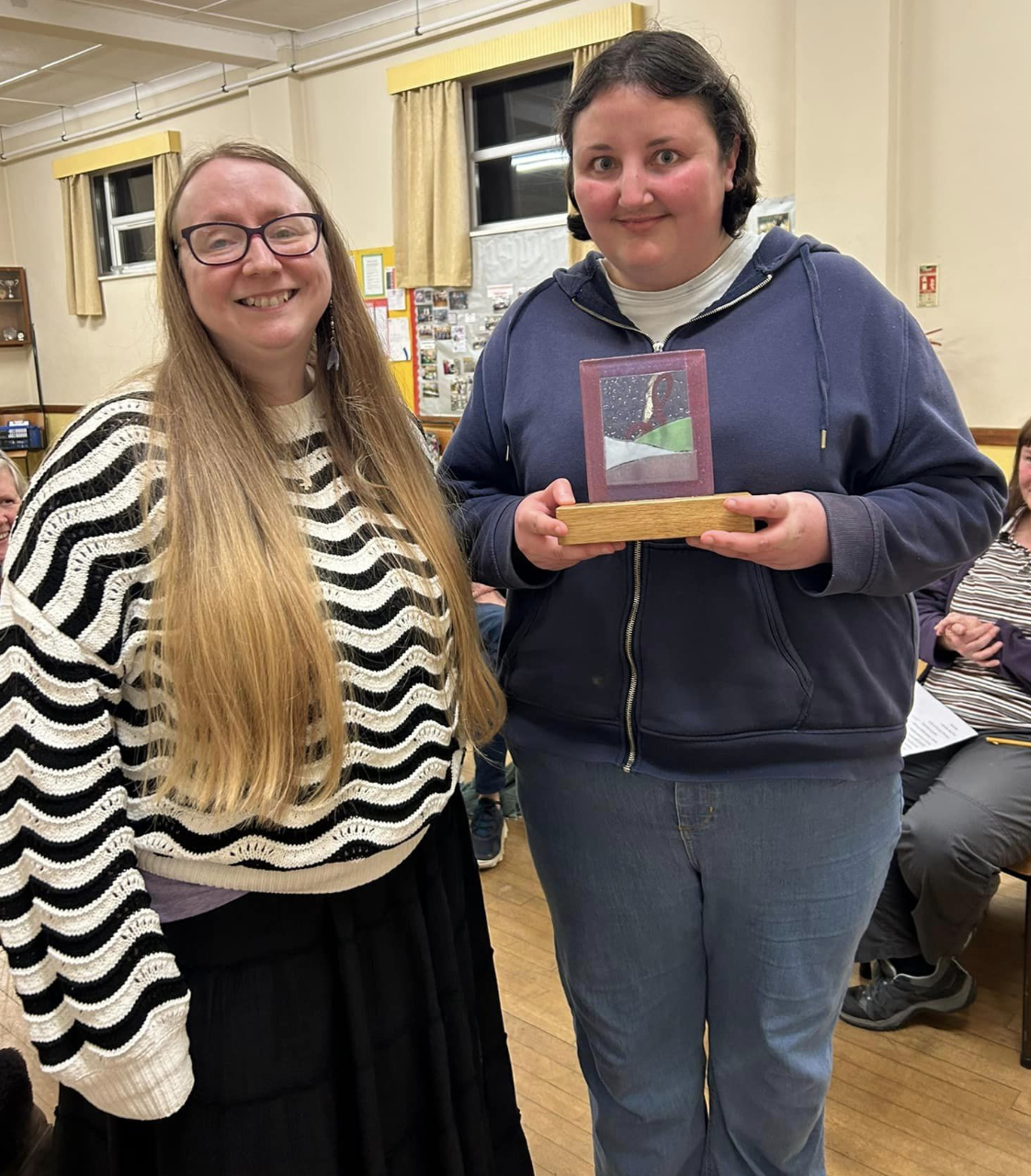 A member of More Harmony choir being presented with an award by our Musical Director